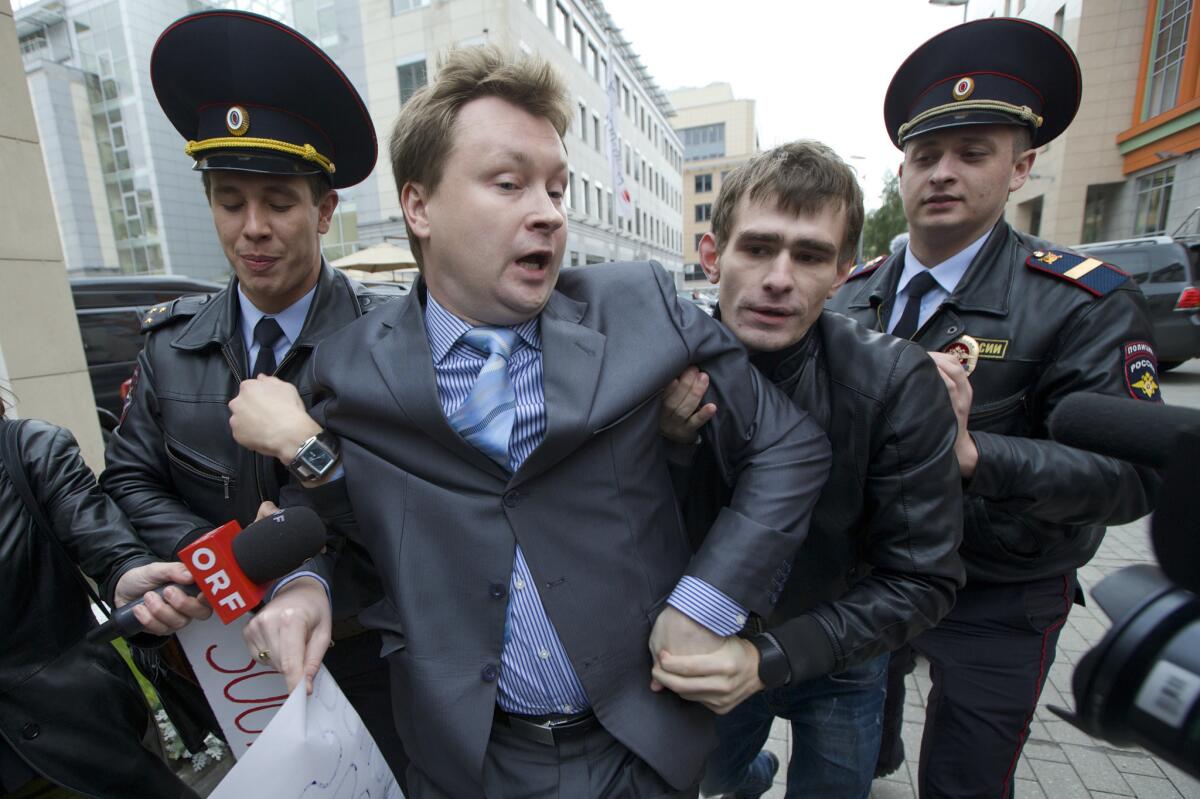 Police detain Russian gay rights activist Nikolai Alexeyev, center, during a protest Sept. 25, 2013, in downtown Moscow.