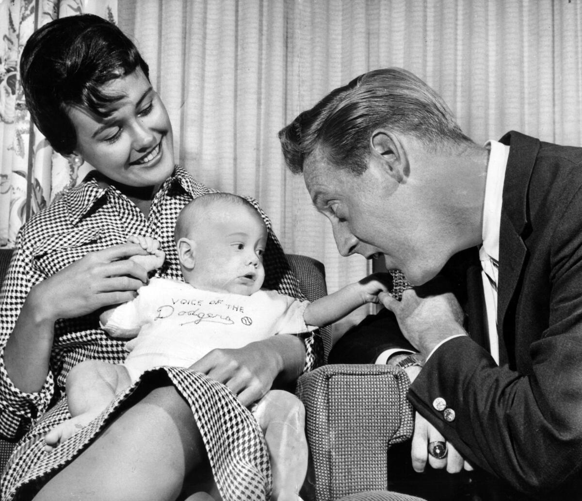 Joan and Vin Scully hold their two-month-old son Michael in April 1960. (Los Angeles Times)