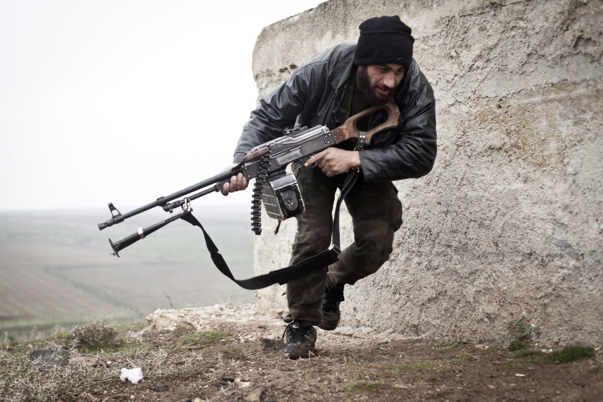 A Free Syrian Army fighter takes cover during clashes with government forces in Azaz in December.
