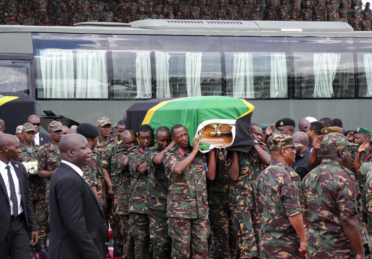 Members of the military carry the body of the late Tanzanian President John Magufuli 