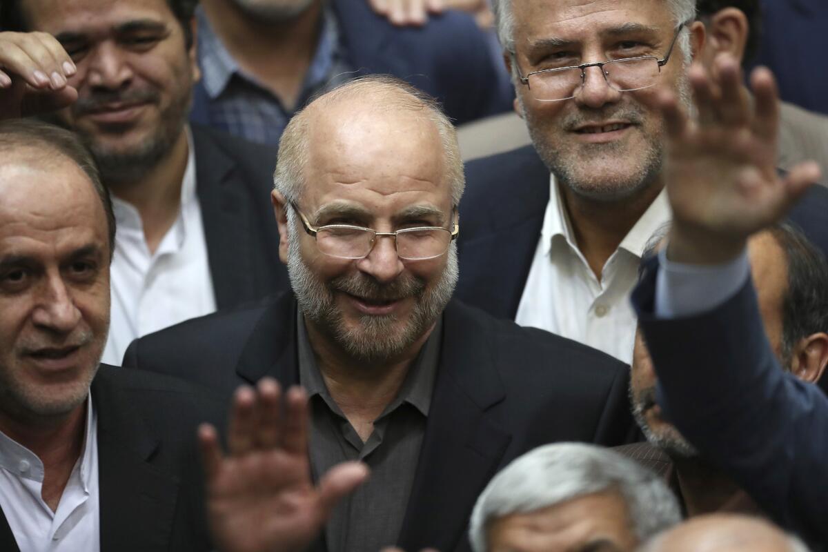 Iran parliament speaker Mohammad Bagher Qalibaf is surrounded by other men.