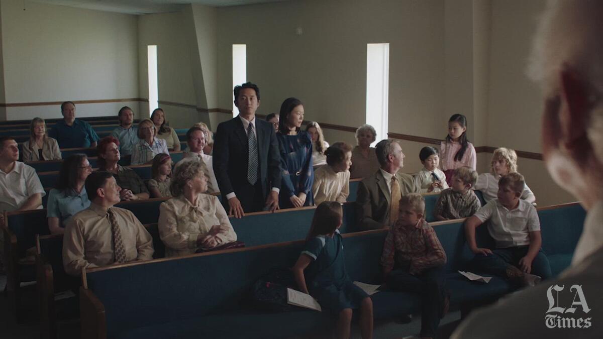 A Korean American family stands while congregants in a mostly white church clap for them