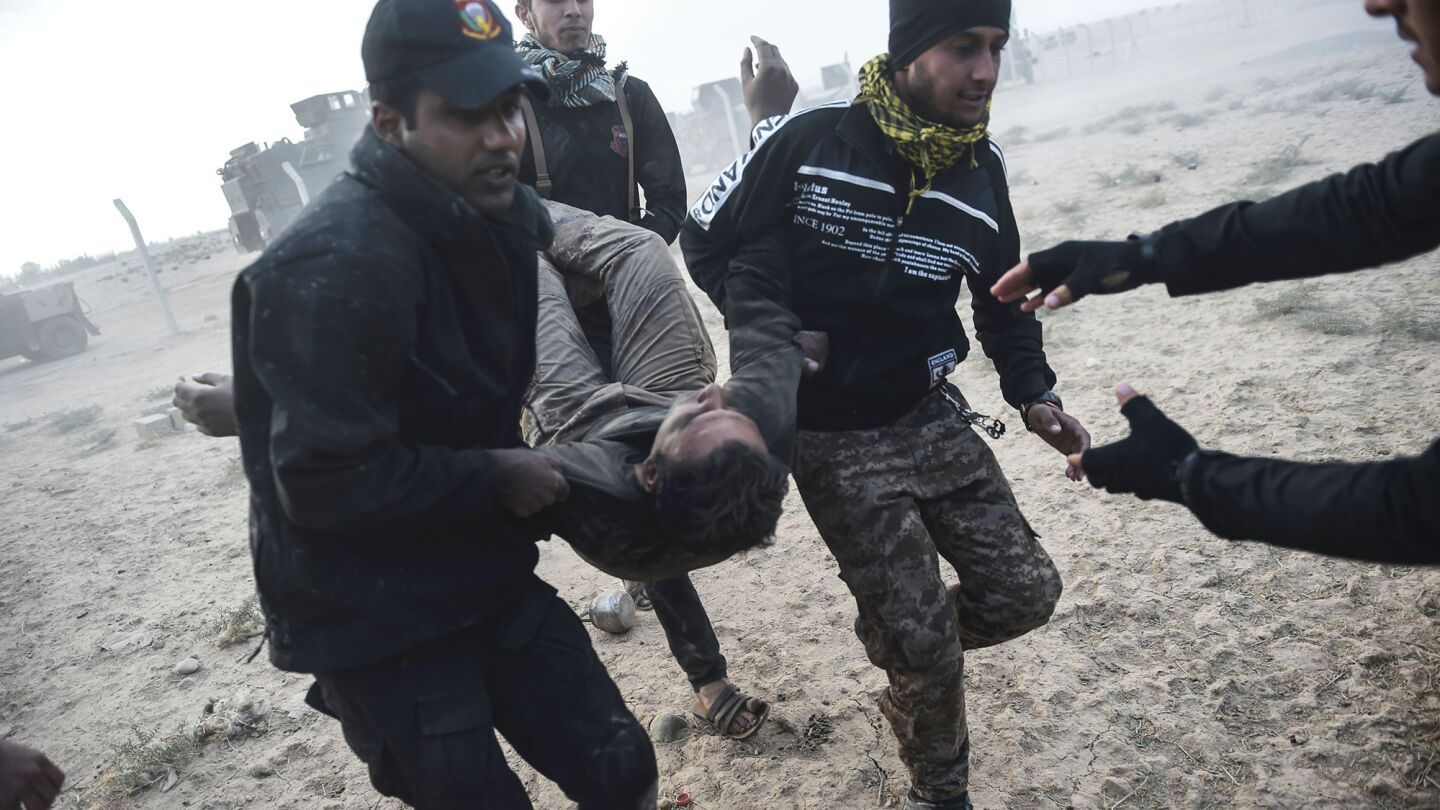 Iraqi counterterrorism members carry an injured comrade during clashes with the Islamic State near Bazwaya on Monday. Iraqi forces took control of the village near Mosul.