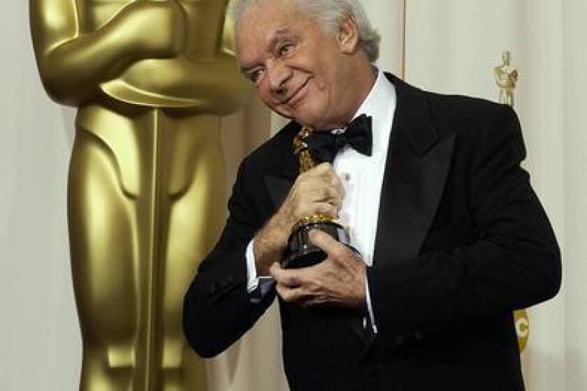 Martin Richards embraces his Oscar statuette after "Chicago" won for best motion picture at the 75th annual Academy Awards in Los Angeles in 2003.