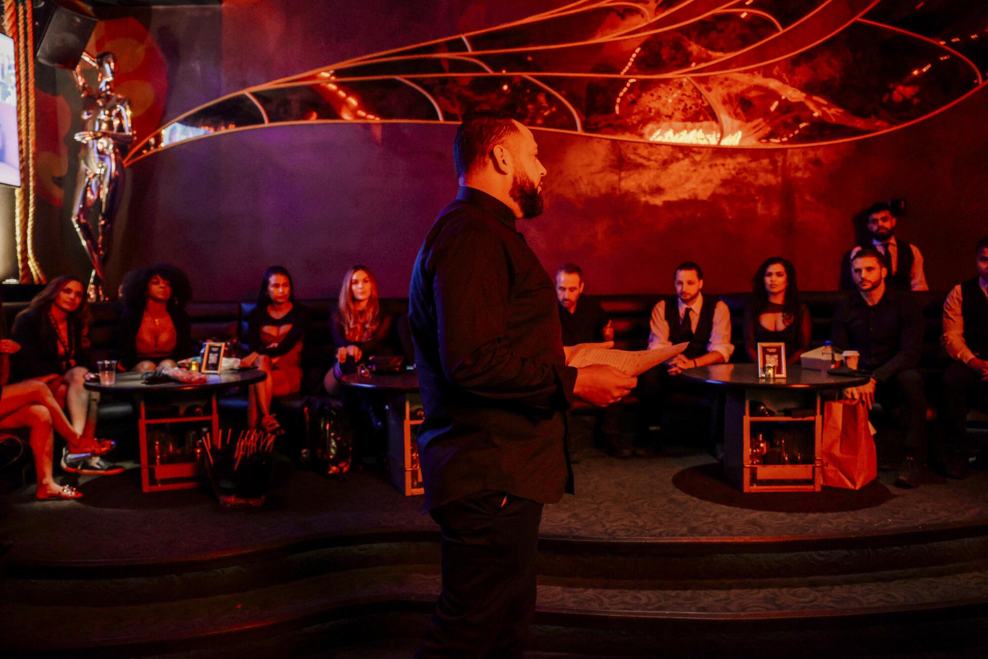 Jesse Saenz speaks to his staff, seated in front of him, before the opening the "Courtside Club" at Miami Heat's arena.