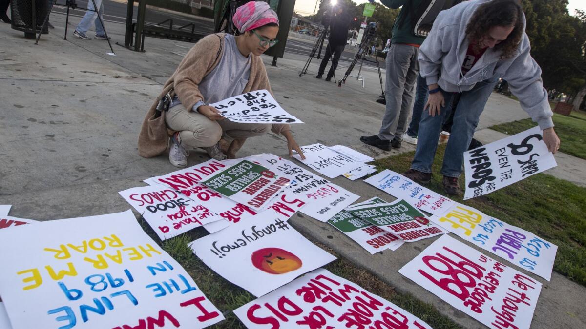 LAUSD teachers, retired teachers and parents gather signs outside Venice High School on Thursday to show their support for a teachers' strike.