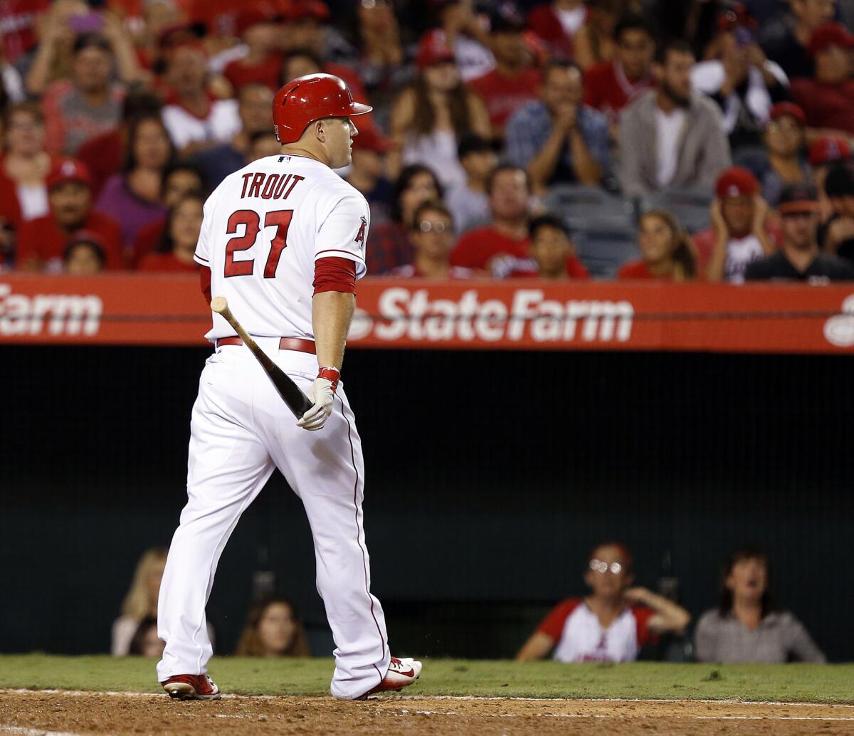 Mike Trout camina al dugout tras ser puesto out...