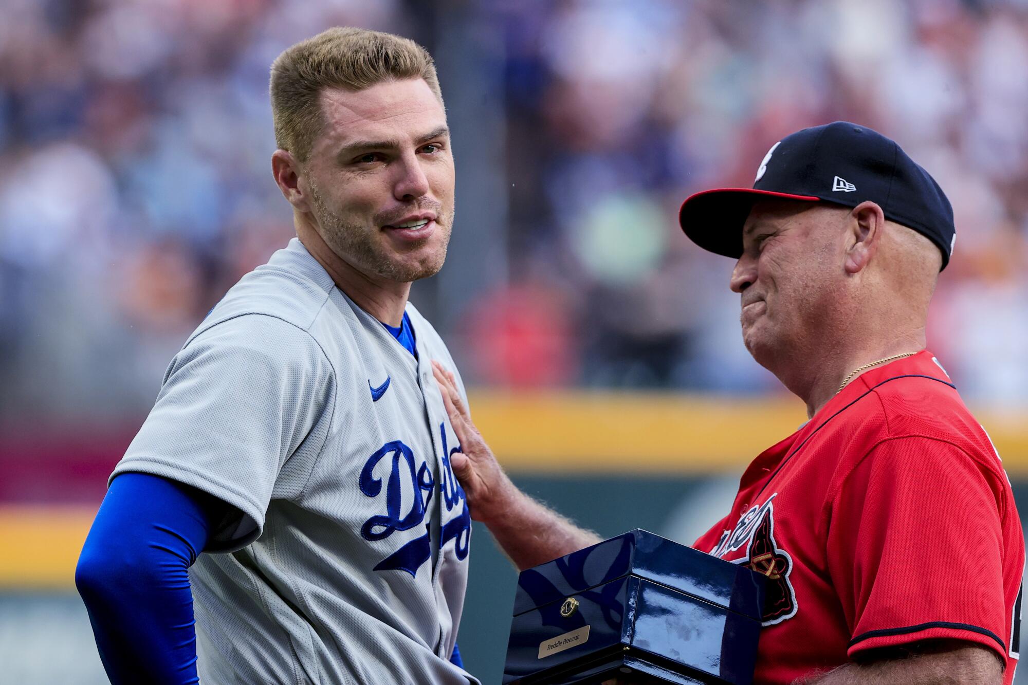 Dodgers first baseman Freddie Freeman receives his World Series championship ring from Atlanta Braves manager Brian Snitker.