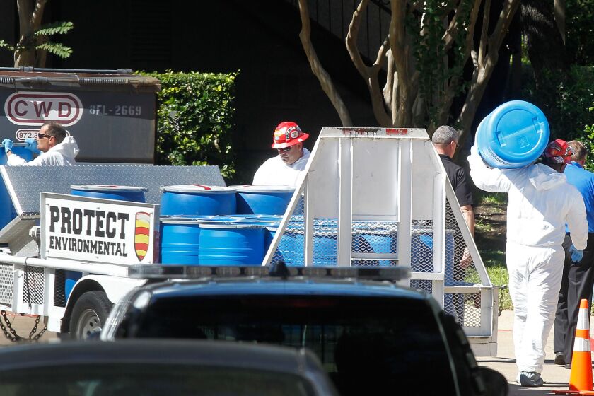 Hazmat workers unload barrels in preparation for decontaminating a Dallas apartment where a second healthcare worker with Ebola lives.
