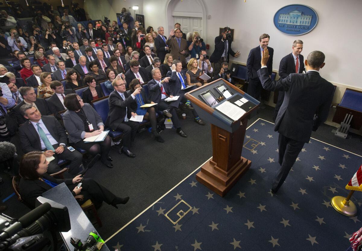 President Obama waves to reporters at the conclusion of his news conference in the White House press briefing room in Washington on Friday.