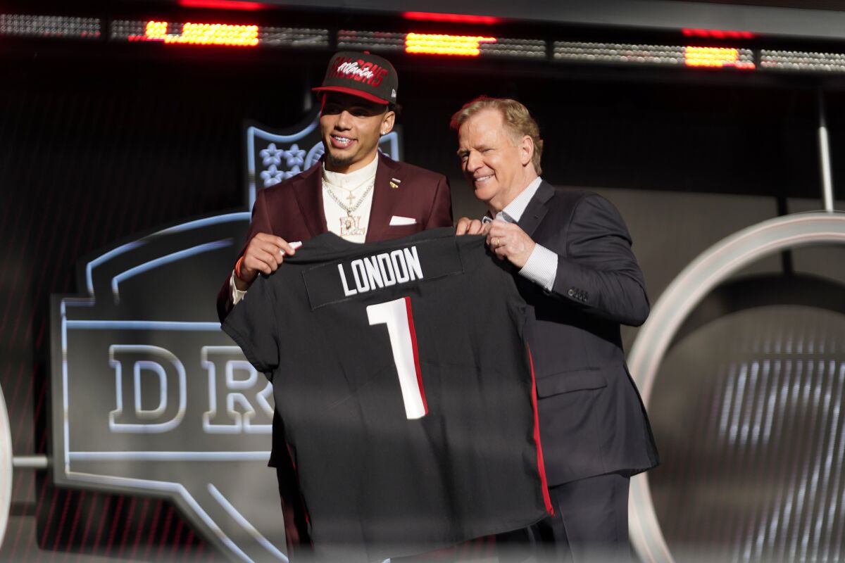 USC wide receiver Drake London and NFL commissioner Roger Goodell stand on the draft stage.