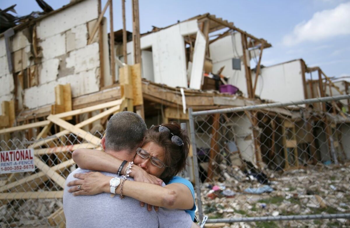 Shona Jupe, a resident of the apartment destroyed by the fertilizer plant explosion, hugs her friend as they met while she was visiting the site in West, Texas. Jupe was at the front door when the West Fertilizer Co. explosion happened.