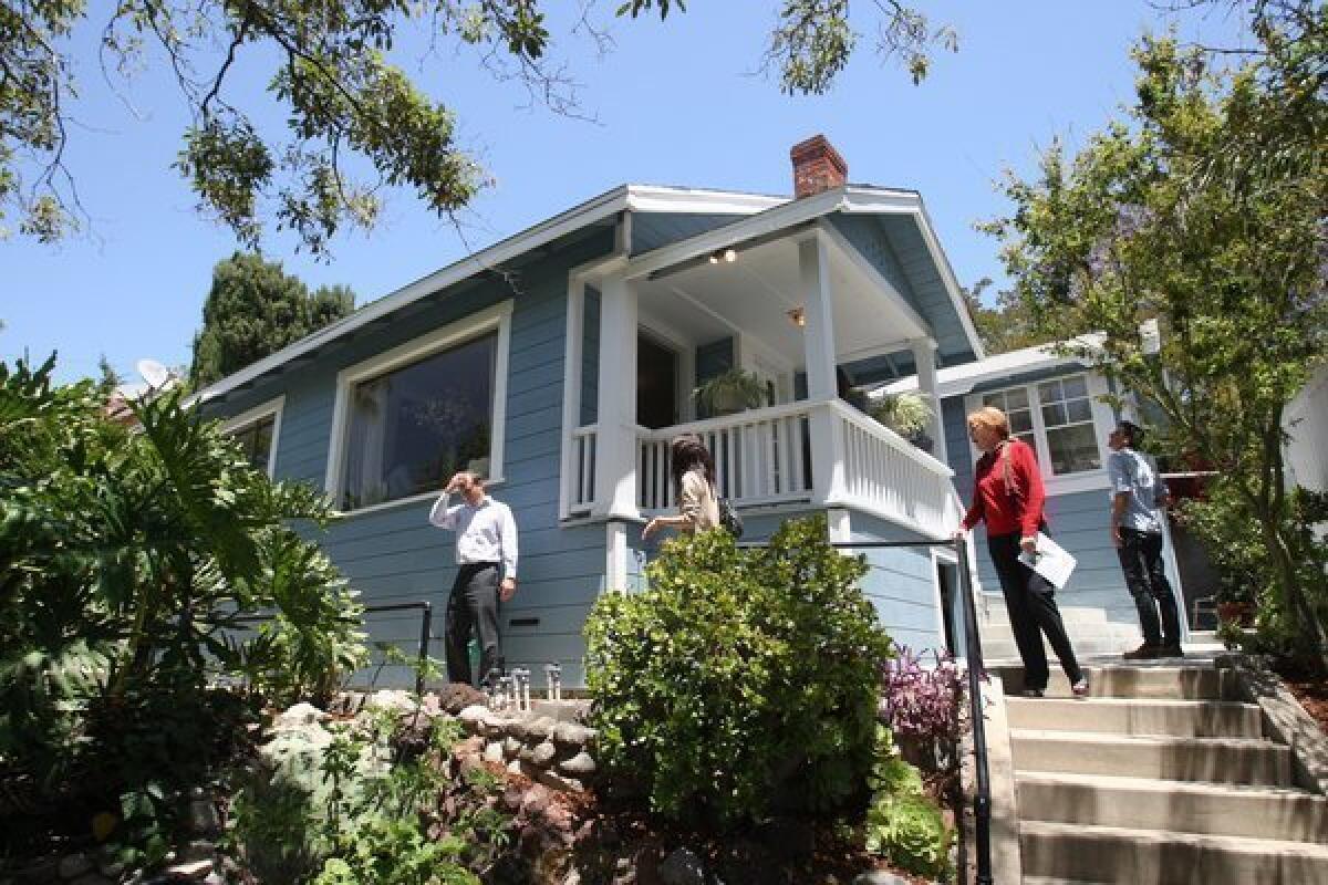 Buyers, Realtors and brokers look over a 1920s California Bungalow for sale in Highland Park.
