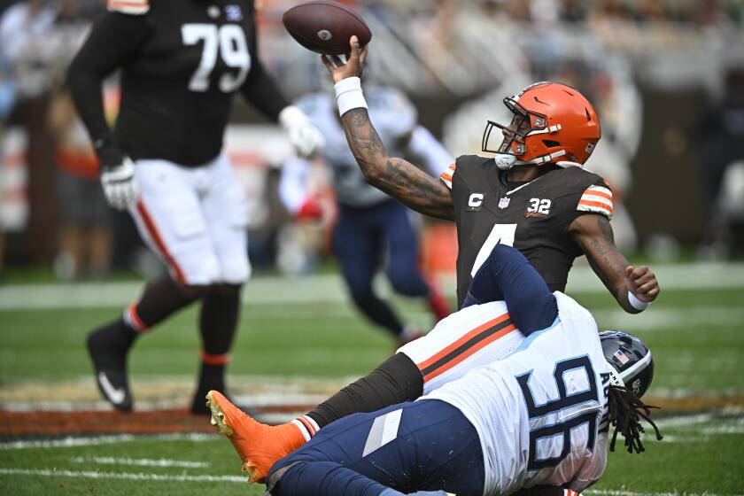 Cleveland Browns quarterback Deshaun Watson, left, throws a pass as he is pulled down by Tennessee Titans defensive end Denico Autry (96) during the first half of an NFL football game Sunday, Sept. 24, 2023, in Cleveland. (AP Photo/David Richard)