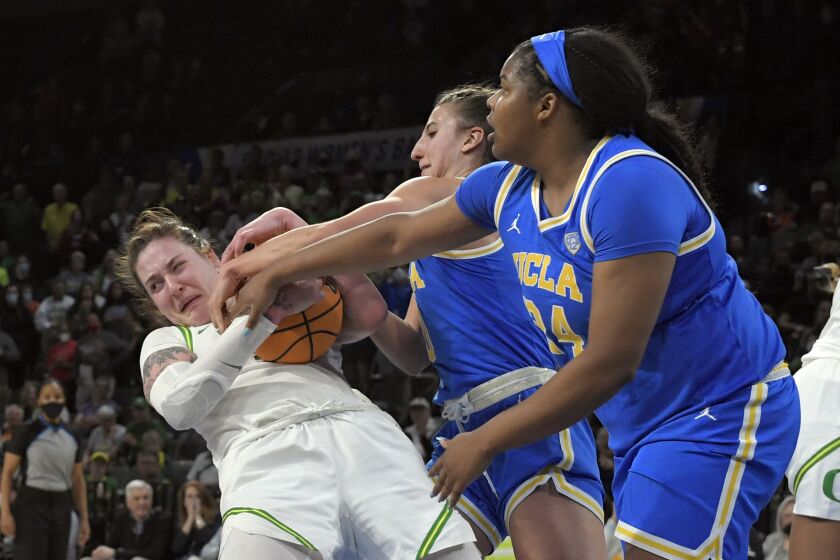 Oregon forward Sedona Prince (32) grabs the ball against UCLA guard Chantel Horvat (0) and forward IImar'I Thomas (24) during an NCAA college basketball game in the quarterfinals of the Pac-12 women's tournament Thursday, March 3, 2022, in Las Vegas. (AP Photo/David Becker)