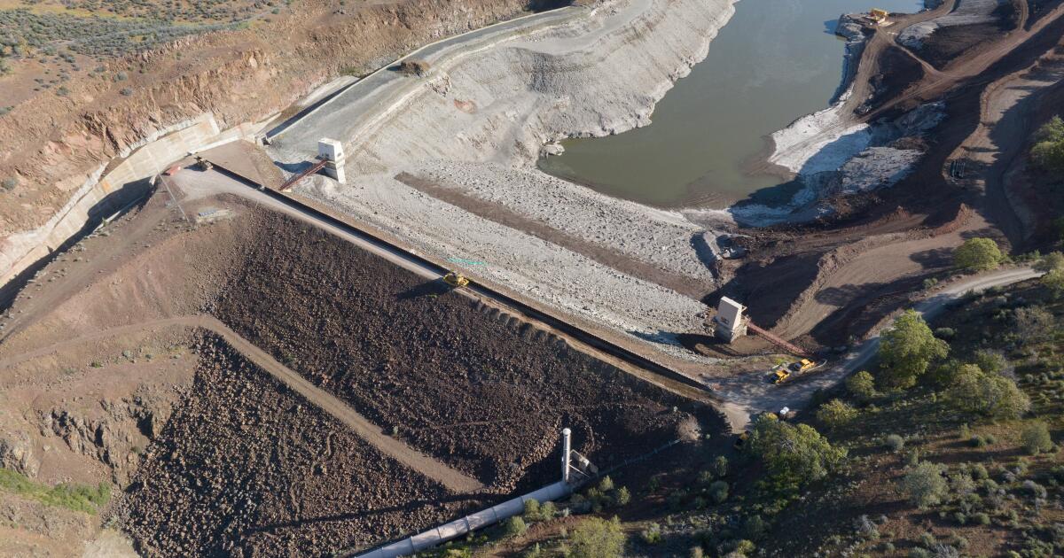 Workers have begun dismantling the largest dam on the Klamath River, using machinery to scoop the first loads of rocks from an earthen barrier that ha