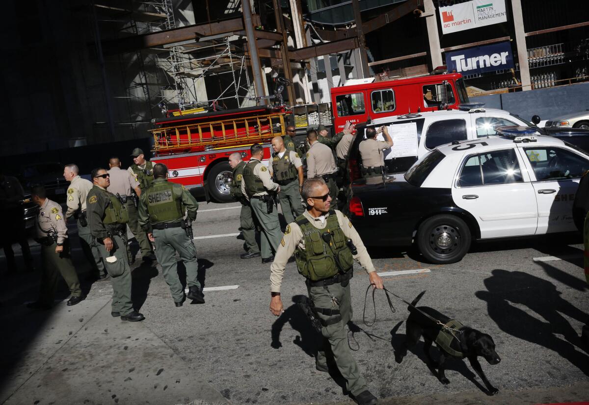 L.A. County sheriff's Deputy Rich Faulk conducts a sweep with his dog, Clyde, in downtown Los Angeles after the 7th Street/Metro Center train stop was evacuated after smoke began to fill the station.