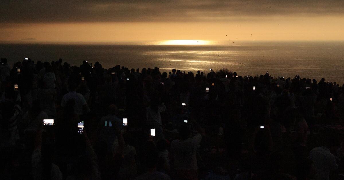 Photo: latimes.com A CORUNA, SPAIN - AUGUST 12: Despite being blocked by clouds, people continue to record with their phones during the total