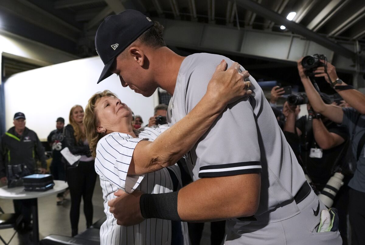 New York Yankees' Aaron Judge hugs his mother, Patty Judge, after the team's baseball game against the Toronto Blue Jays on Wednesday, Sept. 28, 2022, in Toronto. Judge hit his 61st home run of the season. (Nathan Denette/The Canadian Press via AP)