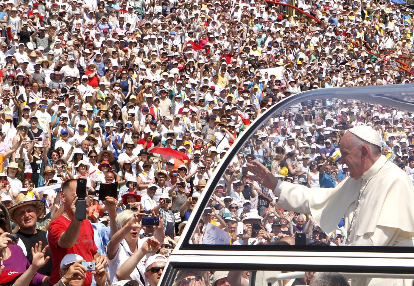 Pope Francis waves to the crowd as he arrives to celebrate Mass at the Kosevo stadium in Sarajevo.