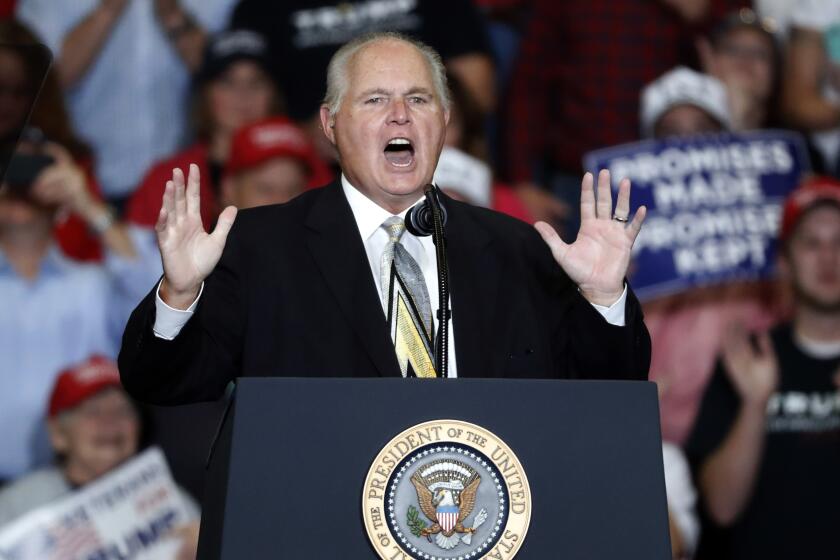 The photo shows radio personality Rush Limbaugh introducing President Donald Trump at a rally in Cape Girardeau, Mo.