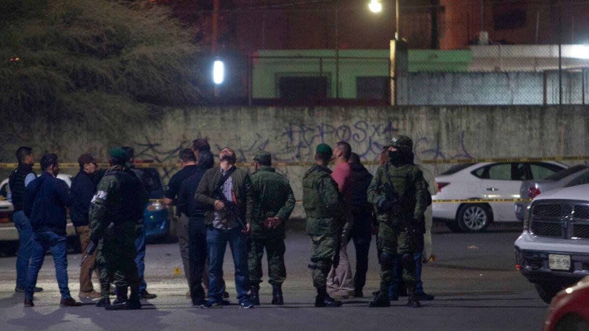 Members of the Mexican army on Sunday monitor the area where nine people were killed inside a house while watching a soccer game near Monterrey, Mexico.
