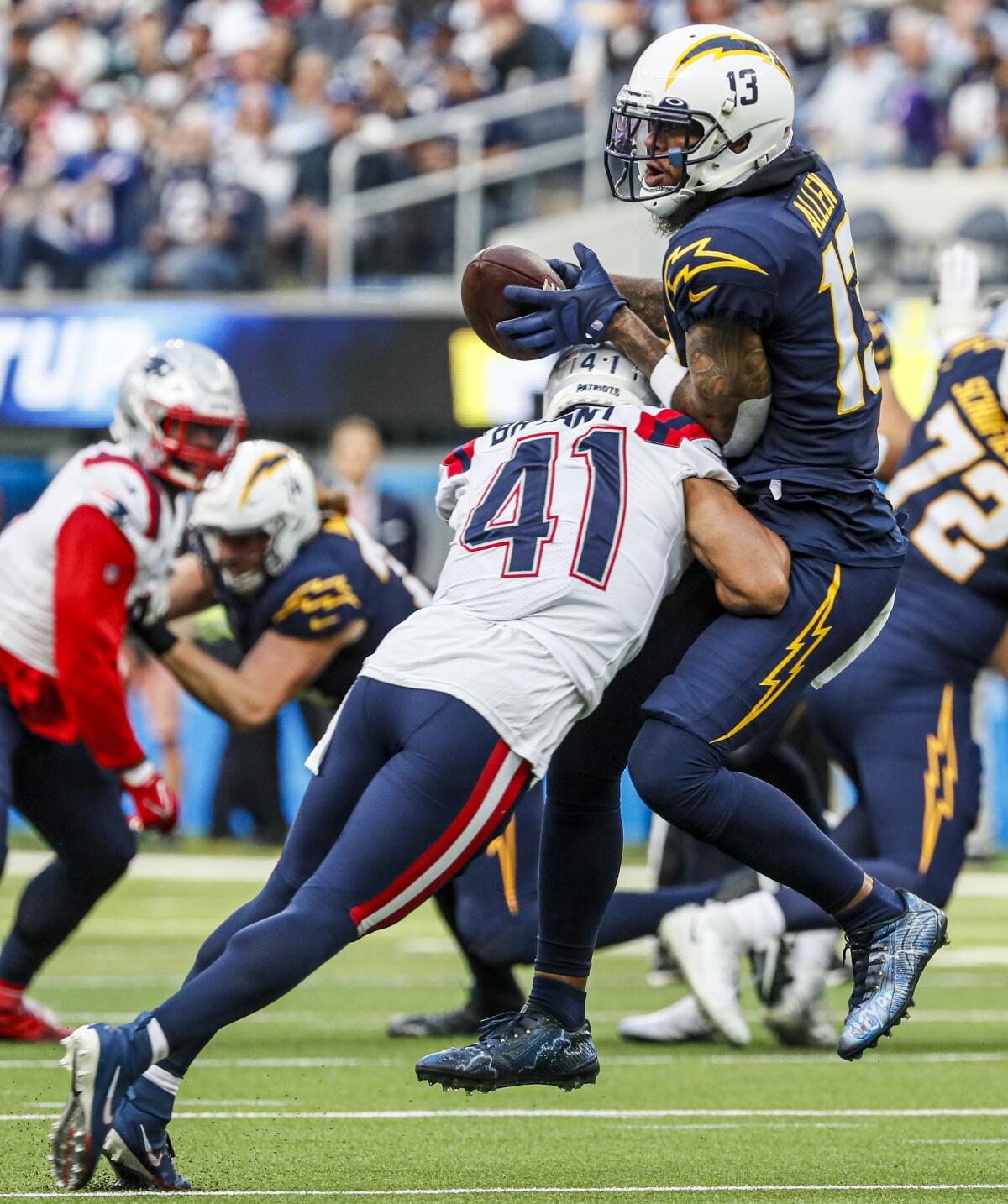 Chargers wide receiver Keenan Allen (13) is separated from the ball by  Patriots cornerback Myles Bryant (41).