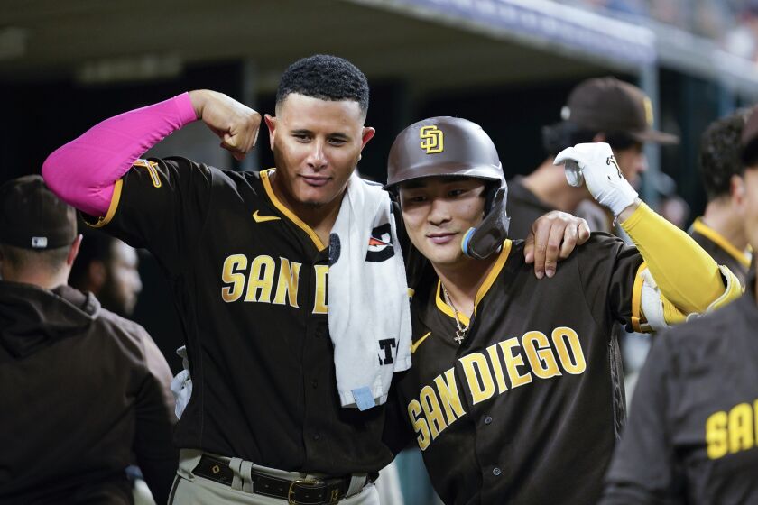 El dominicano Manny Machado felicita a Ha-Seong Kim, quien bateó un jonrón por los Padres de San Diego ante los Tigres de Detroit, el sábado 22 de julio de 2023 (AP Foto/Paul Sancya)