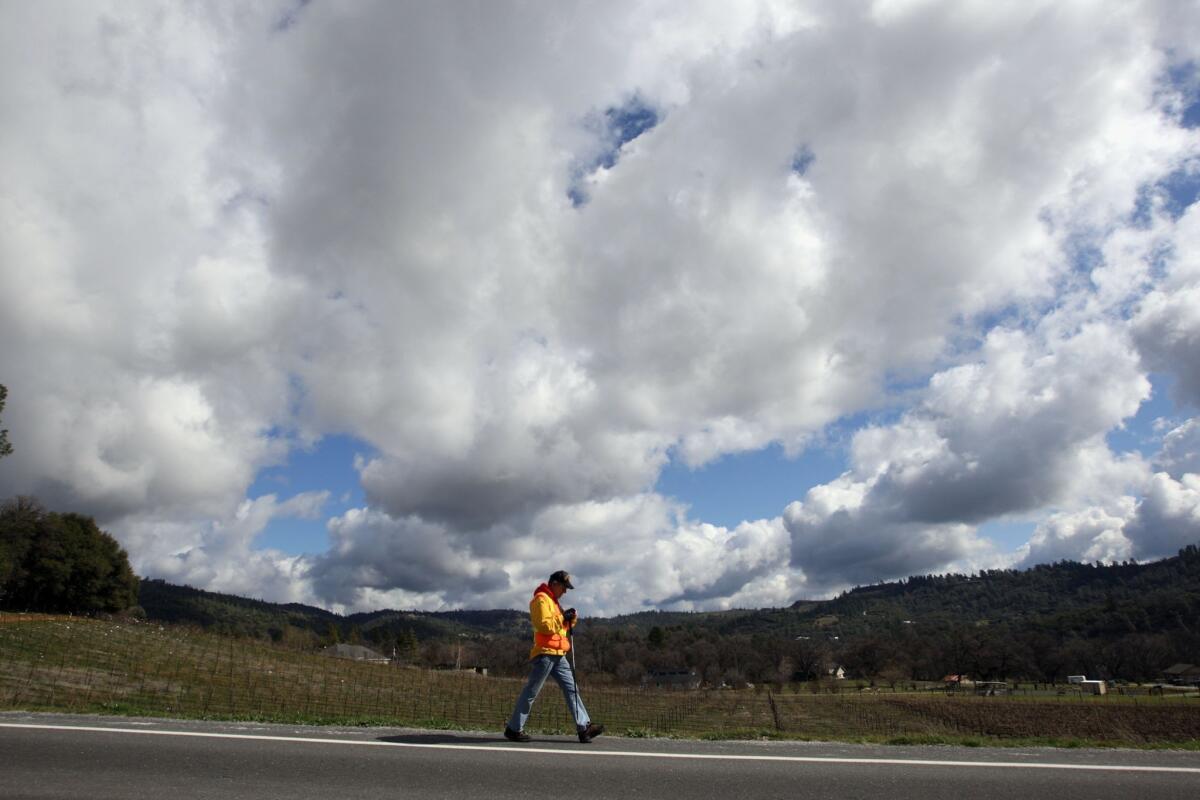 Ric Ryan strolls along California 4 near Murphys, in Calaveras County. Known as the the Walking Man of Murphys, Ryan, a 67-year-old Vietnam veteran with two bum knees, has raised $19,000 over the last two years for UCLA's Operation Mend.