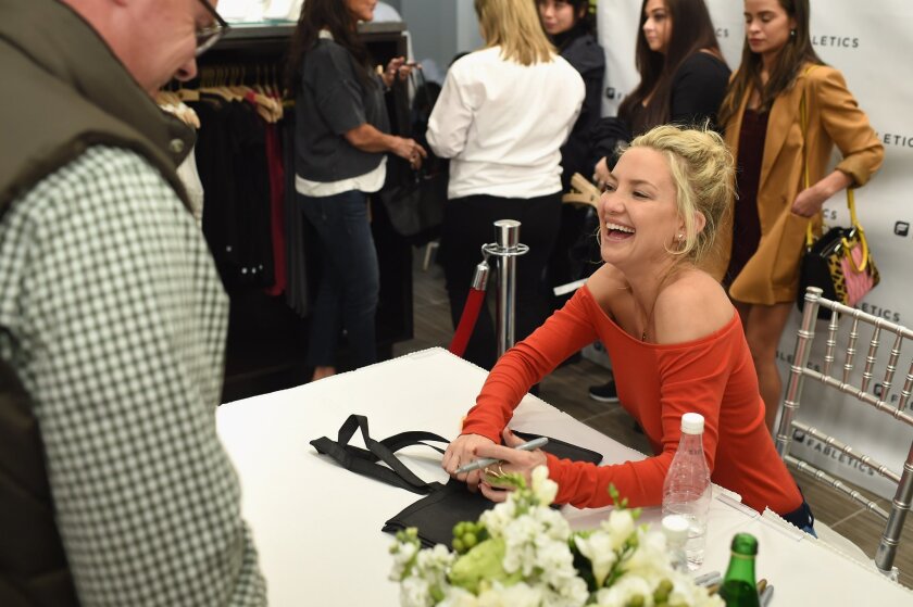 Kate Hudson laughs with a customer as she opens a Fabletics Boutique in Bridgewater, N.J., on Oct. 16.