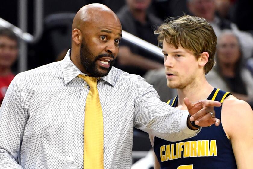 Cuonzo Martin talks to guard Grant Mullins during California's game against Utah in the quarterfinals of the Pac-12 Conference tournament.