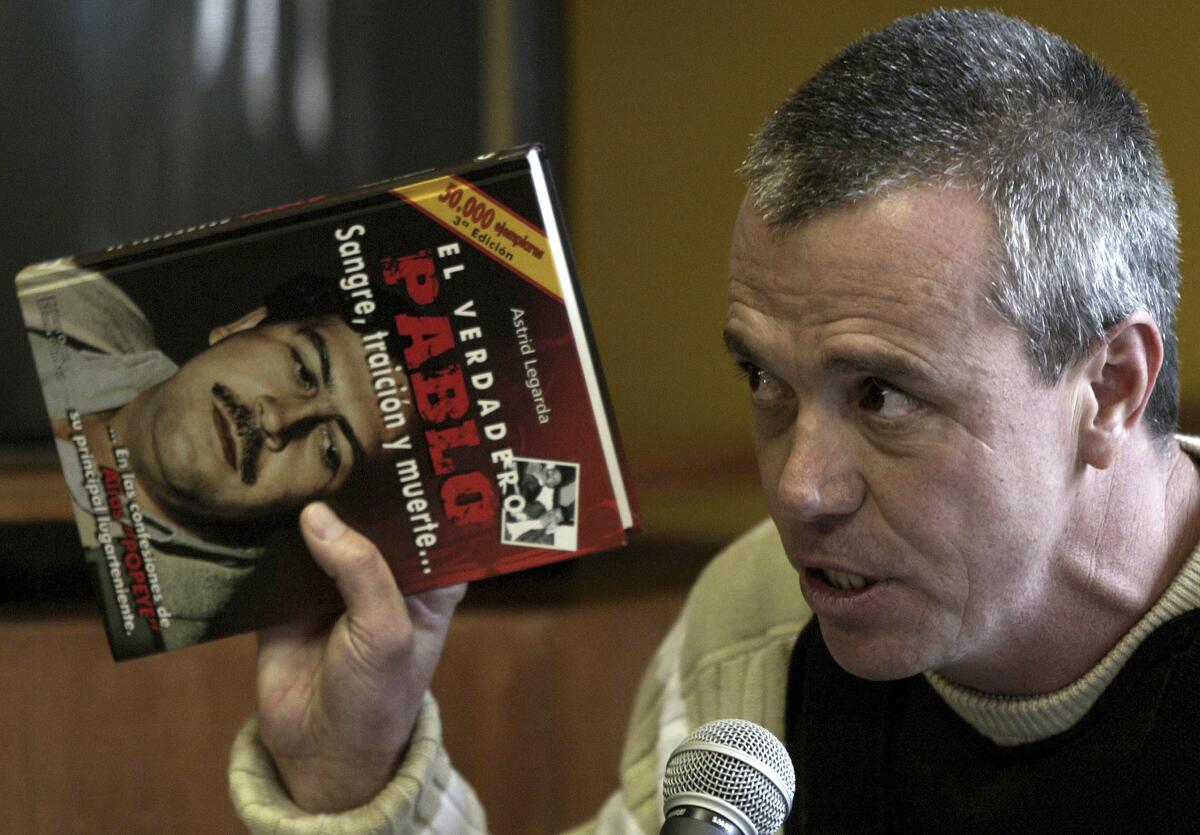 In June 27, 2006, Jhon Jairo Velasquez, a former hit man for Pablo Escobar, testifies while holding a book titled "The True Pablo, Blood, Treason, and Death" during the trial against Alberto Santofimio Botero in Bogota, Colombia.