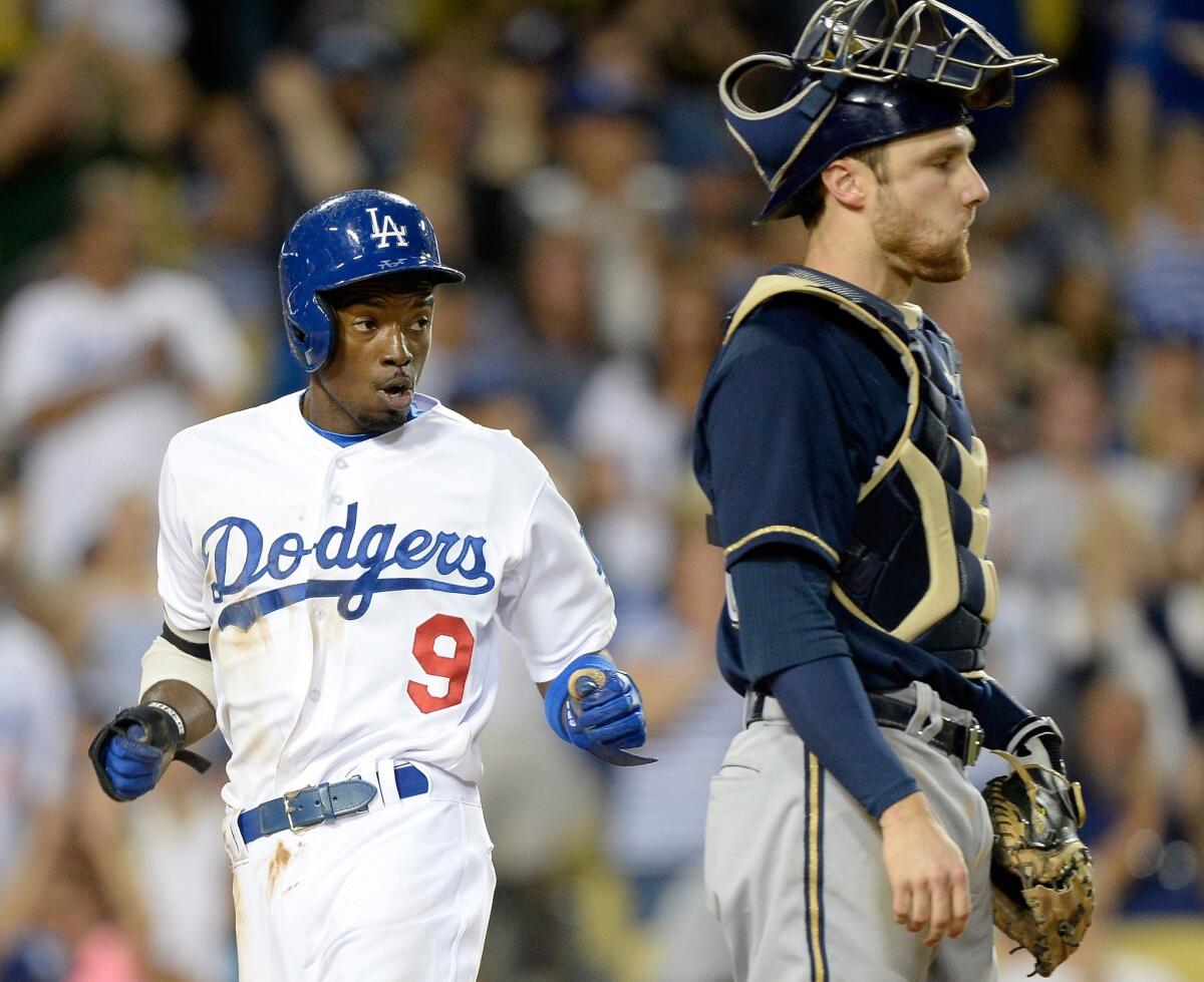 Dee Gordon scores on a singles by Yasiel Puig in the fifth inning of the Dodgers' 6-3 loss to the Brewers on Friday at Dodger Stadium.