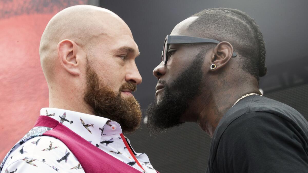 Tyson Fury, left, and Deontay Wilder face off during a news conference in New York.