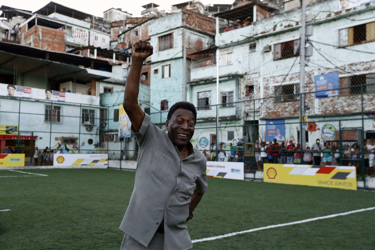 El ex futbolista brasileño Pelé saluda durante la presentación de un nuevo campo de futbol 