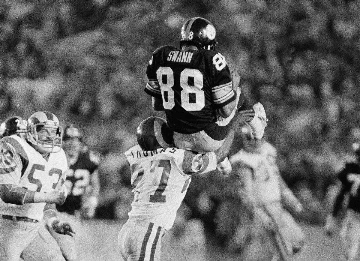 Pittsburgh Steelers receiver Lynn Swann (88) rests briefly on shoulder of Los Angeles Rams defender.