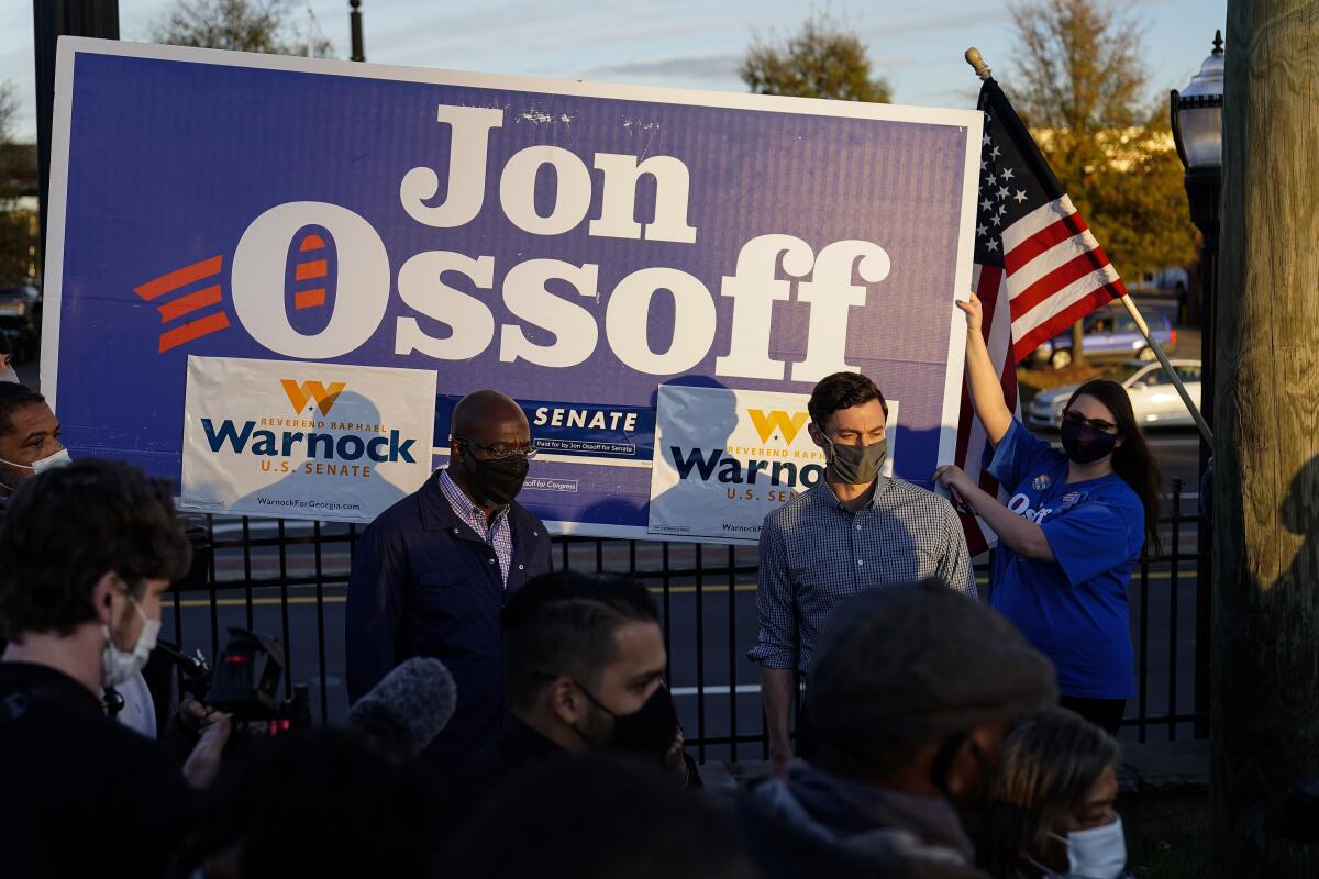 Georgia's Democratic candidates for the U.S. Senate, Raphael Warnock, left, and Jon Ossoff meet with supporters on Nov. 15.