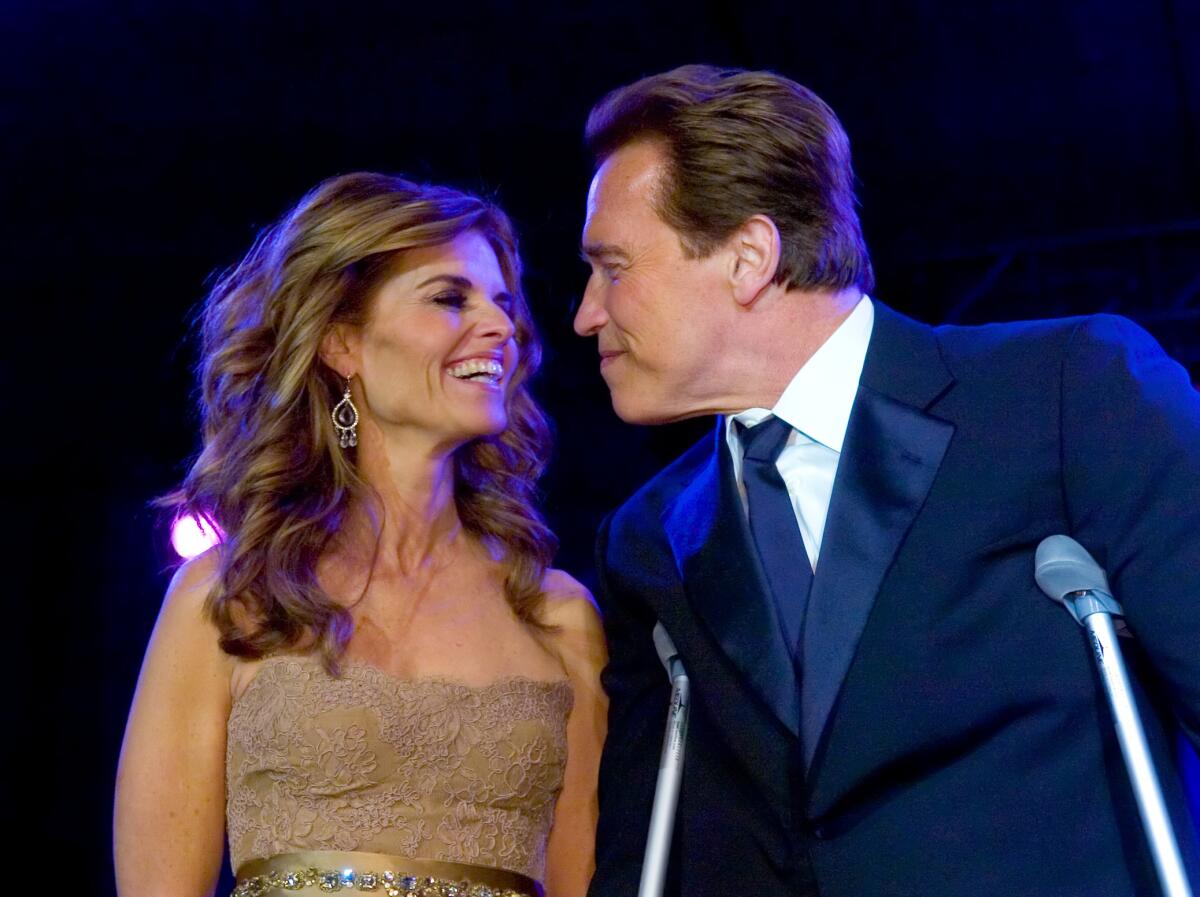 Maria Shriver and Arnold Schwarzenegger, then married, look at one another and smile