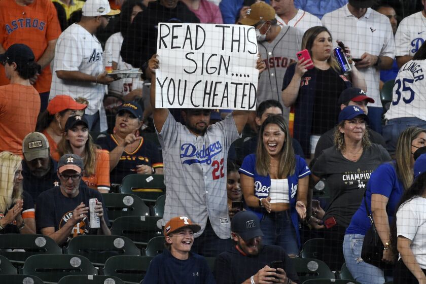 A Los Angeles Dodgers fan holds a sign before a baseball game against the Houston Astros, Tuesday, May 25, 2021, in Houston. (AP Photo/Eric Christian Smith)