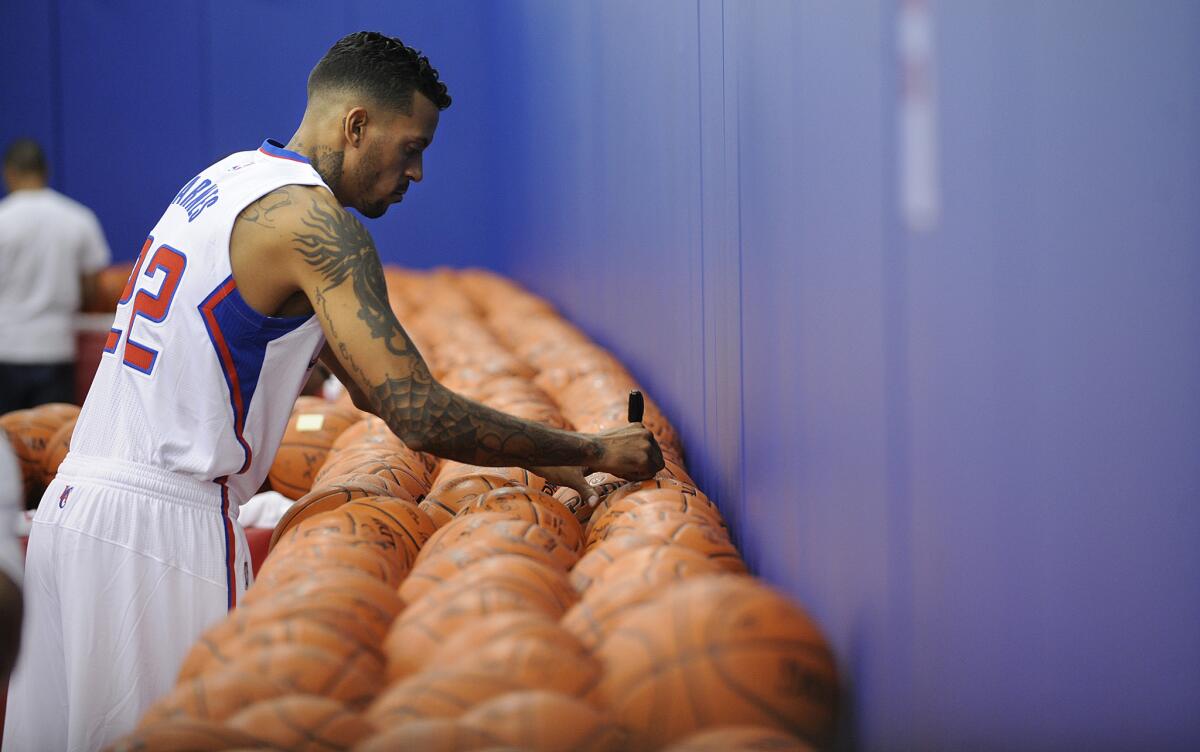 Matt Barnes signs basketballs during Clippers' media day on Monday.