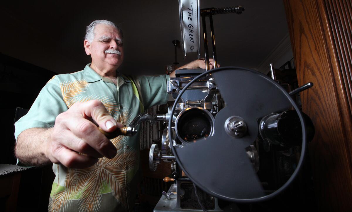 La Crescenta resident Joe Rinaudo shows how a 1912 hand-cranked movie projector works. Rinaudo will be using another 1909 projector to present a silent film screening at Two Strike Park on July 30.