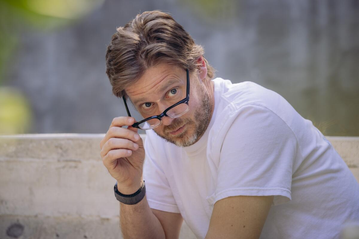 Man with a beard peering over his glasses