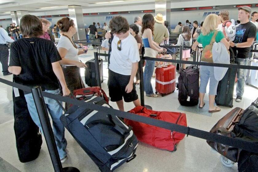 People at LAX wait to check their luggage.