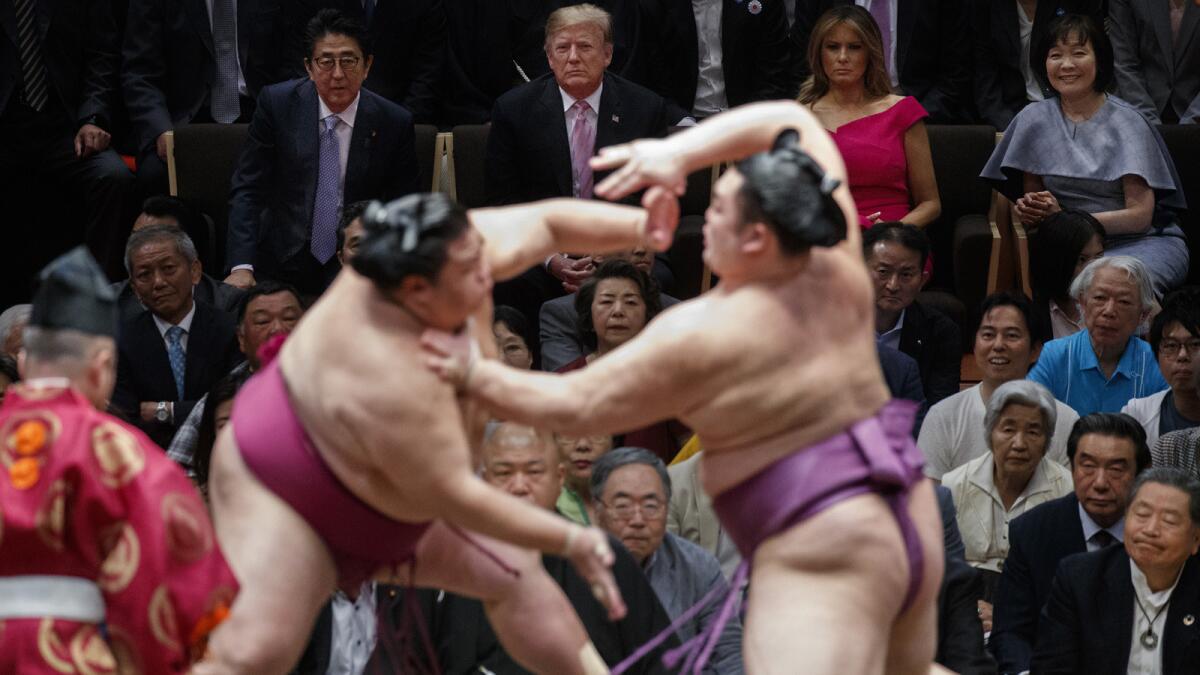 President Trump attends the sumo tournament with Prime Minister Shinzo Abe. At top right are Akie Abe, far right, and First Lady Melania Trump.