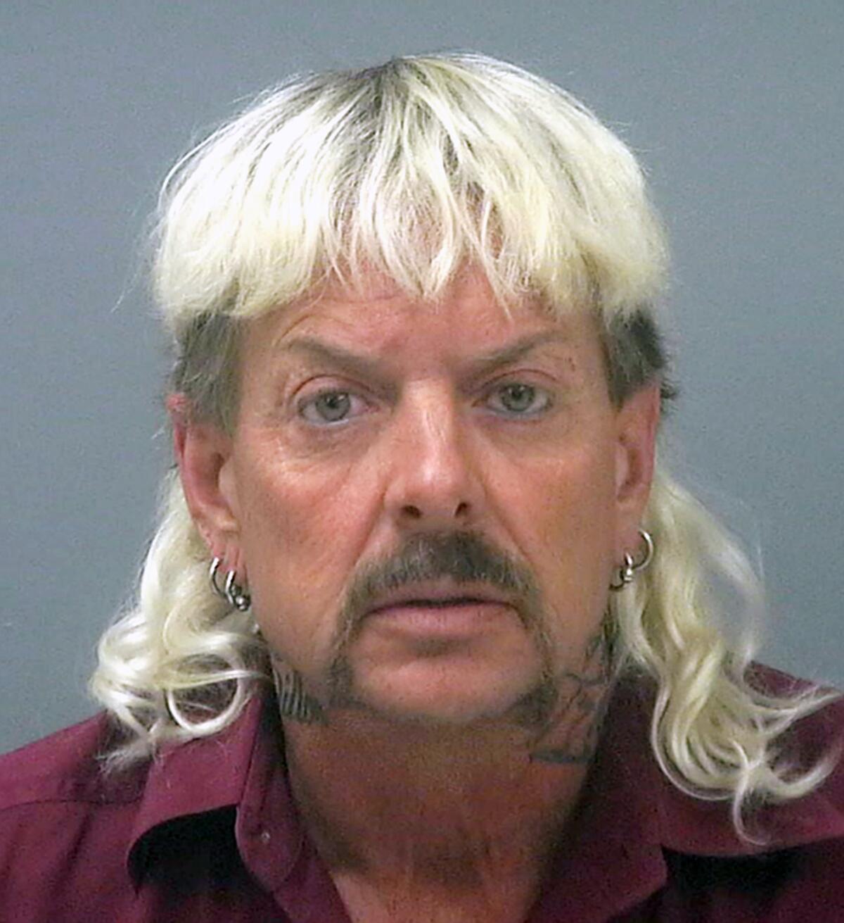 A mug shot of a middle-aged man with a blond mullet and multiple hoop earrings