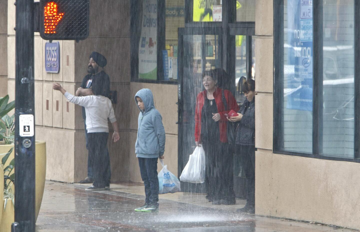 Photo Gallery: Sudden storm catches some without umbrellas in Burbank