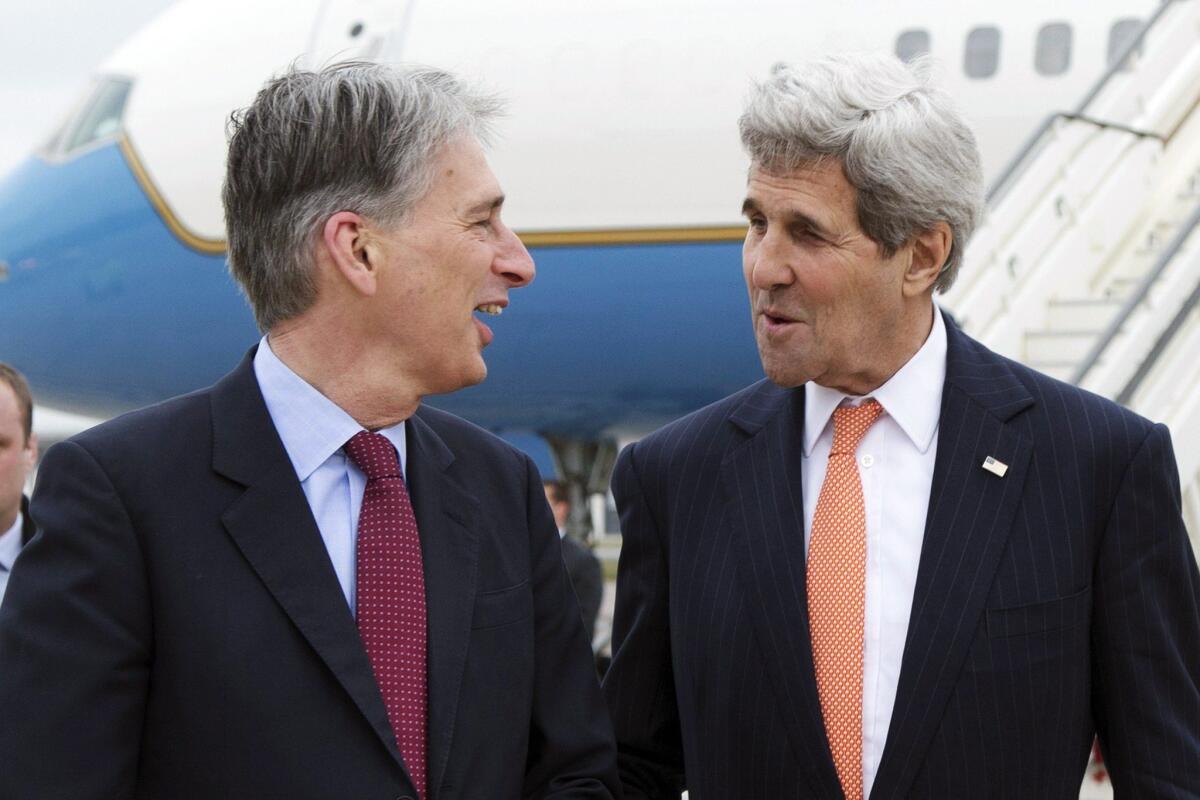 U.S. Secretary of State John Kerry, right, is greeted by British Foreign Secretary Philip Hammond in London on Saturday for a meeting about the recently concluded round of negotiations with Iran over its nuclear program.