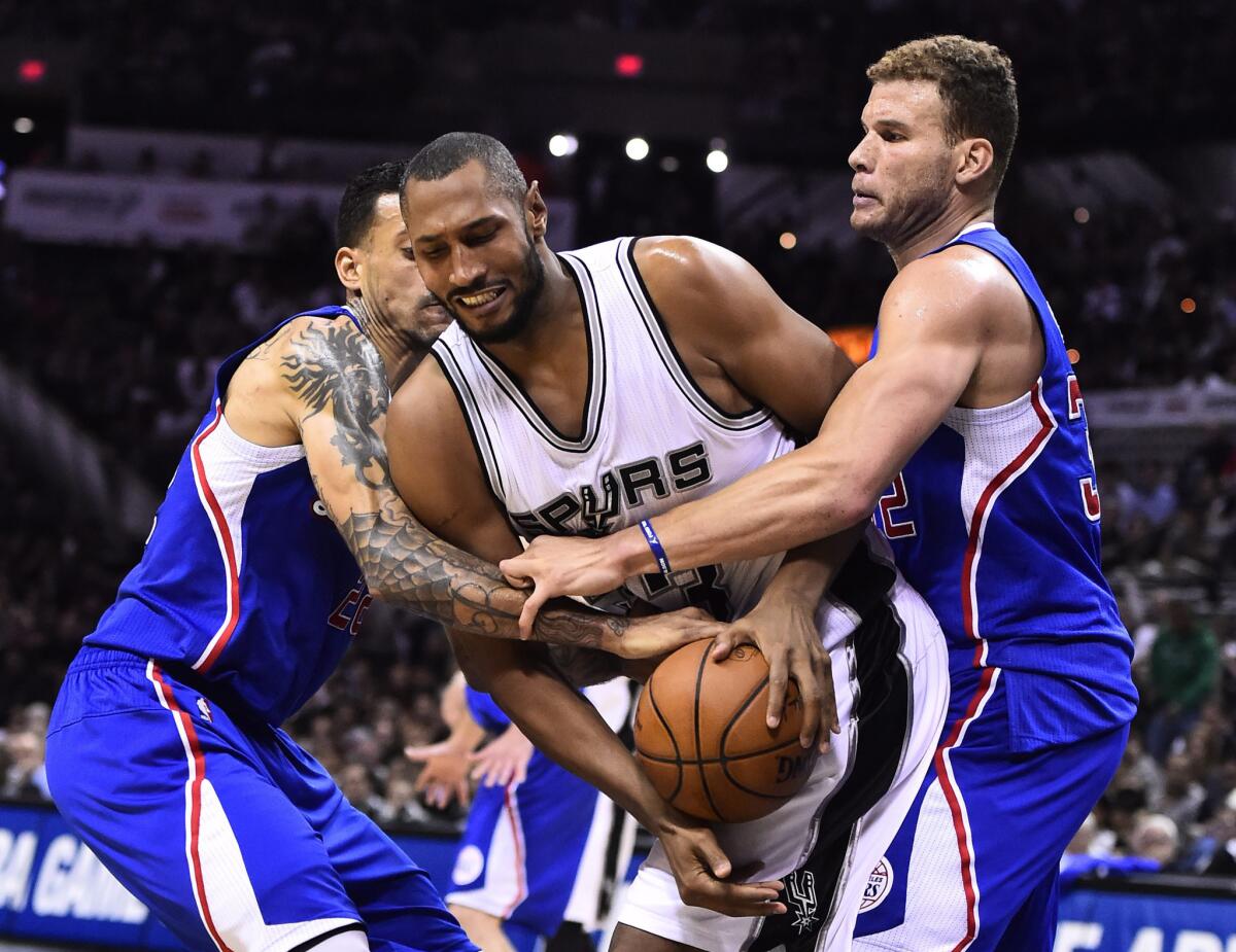 Clippers forwards Blake Griffin, right, and Matt Barnes, left, tie up Spurs forward Boris Diaw in the second half of Game 6.