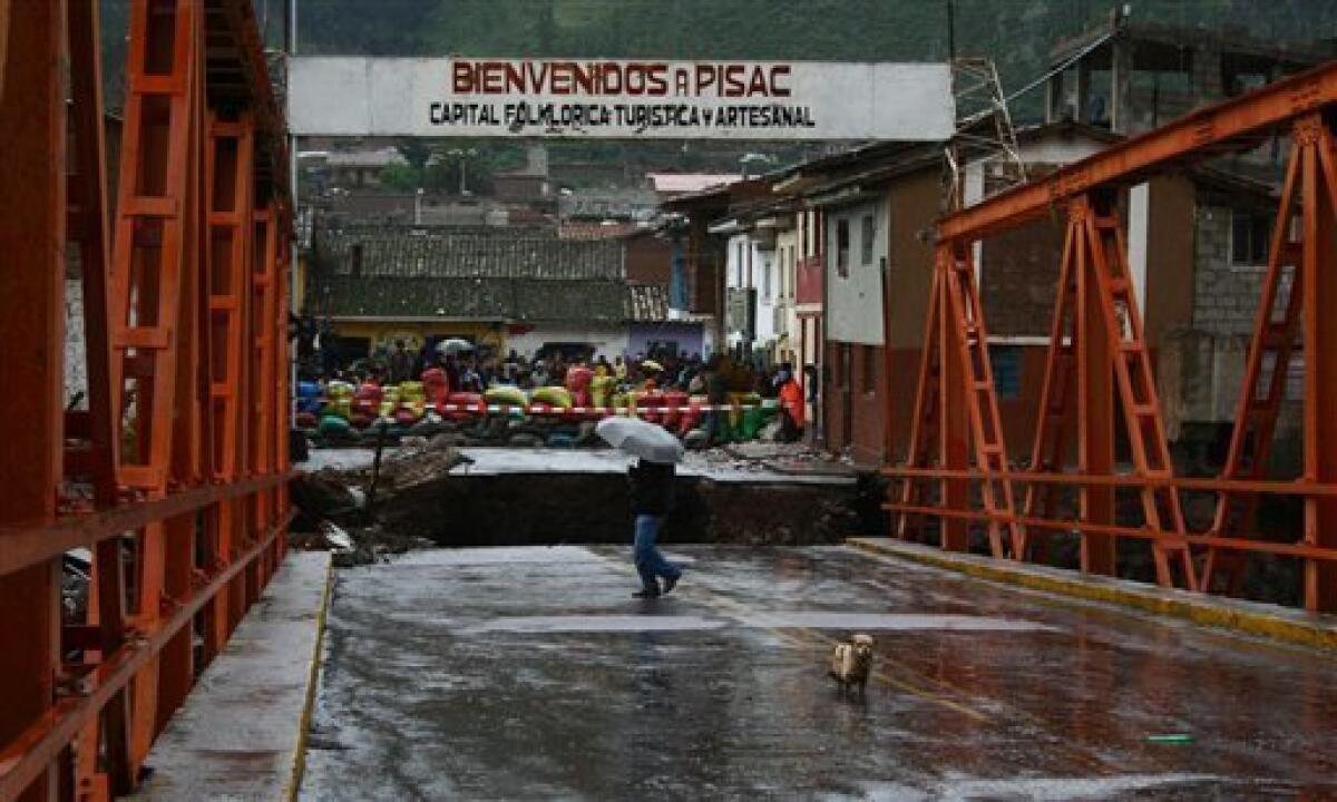A man walks over a destroyed bridge near Inca's Sacred Valley town of Pisac in Cuzco, Peru on Monday, Jan. 25, 2010. Heavy rains and mudslides in Peru blocked the train route to the ancient Inca citadel of Machu Picchu, keeping nearly 2,000 tourists stranded.(AP Photo/Roxabel Ramón/El Comercio)