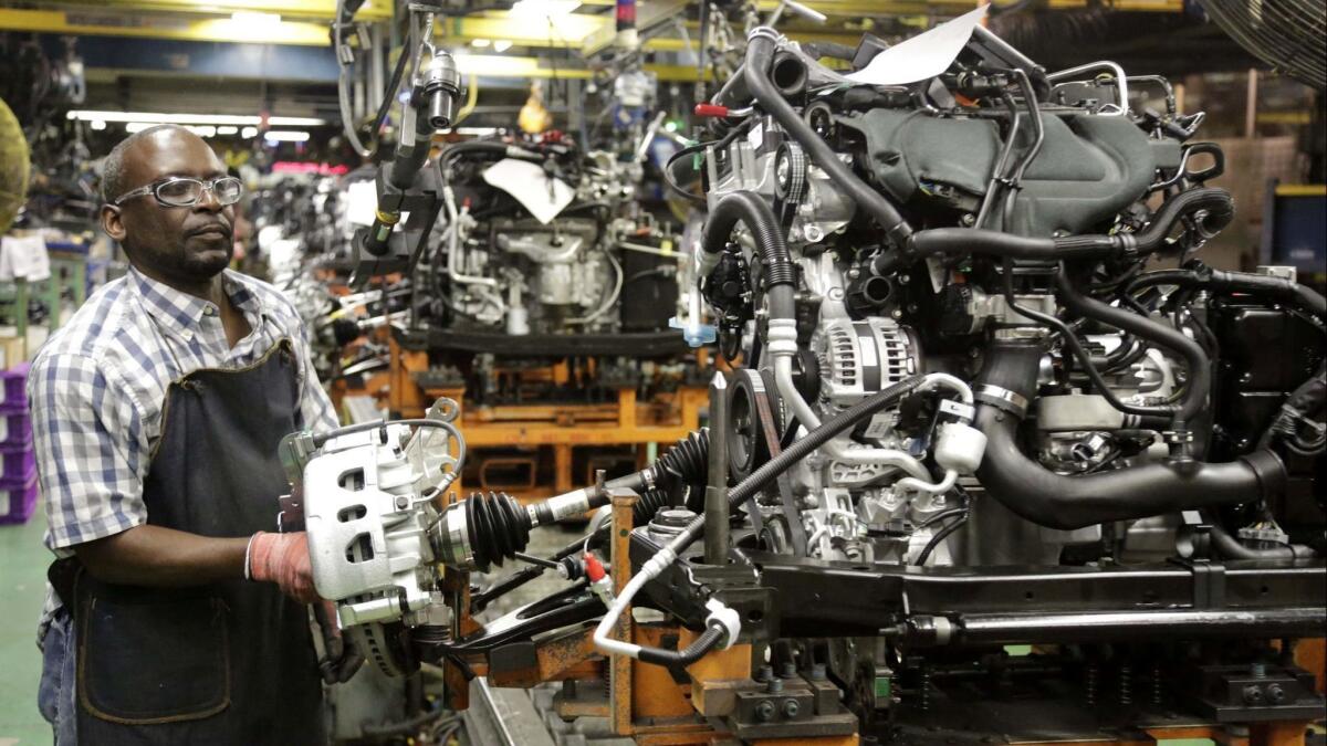 A worker assembles an engine at Ford's Chicago Assembly Plant on June 9, 2015.